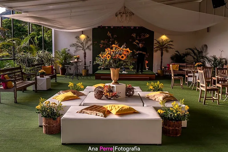 Lounge na varanda com pufes, almofadas e arranjos de girassóis