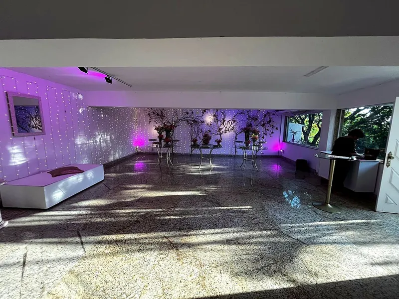 Salão interno com piso de granito e iluminação lilás