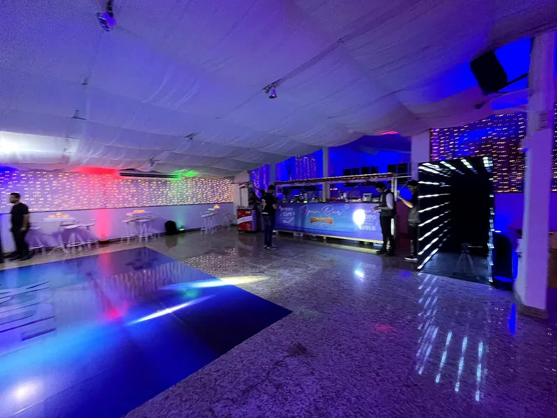 Pista com iluminação azul e bar ao fundo