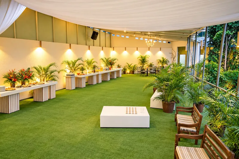 Varanda com bancos de madeira, plantas e iluminação suave