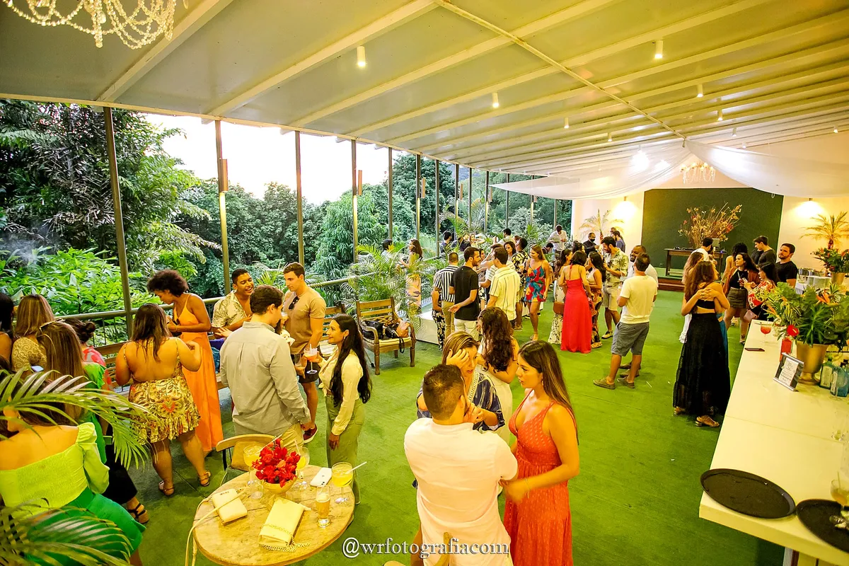Convidados reunidos na varanda com gramado durante evento de dia
