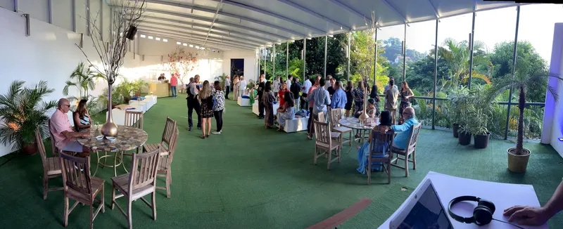 Vista panorâmica da varanda com mesas e convidados em evento