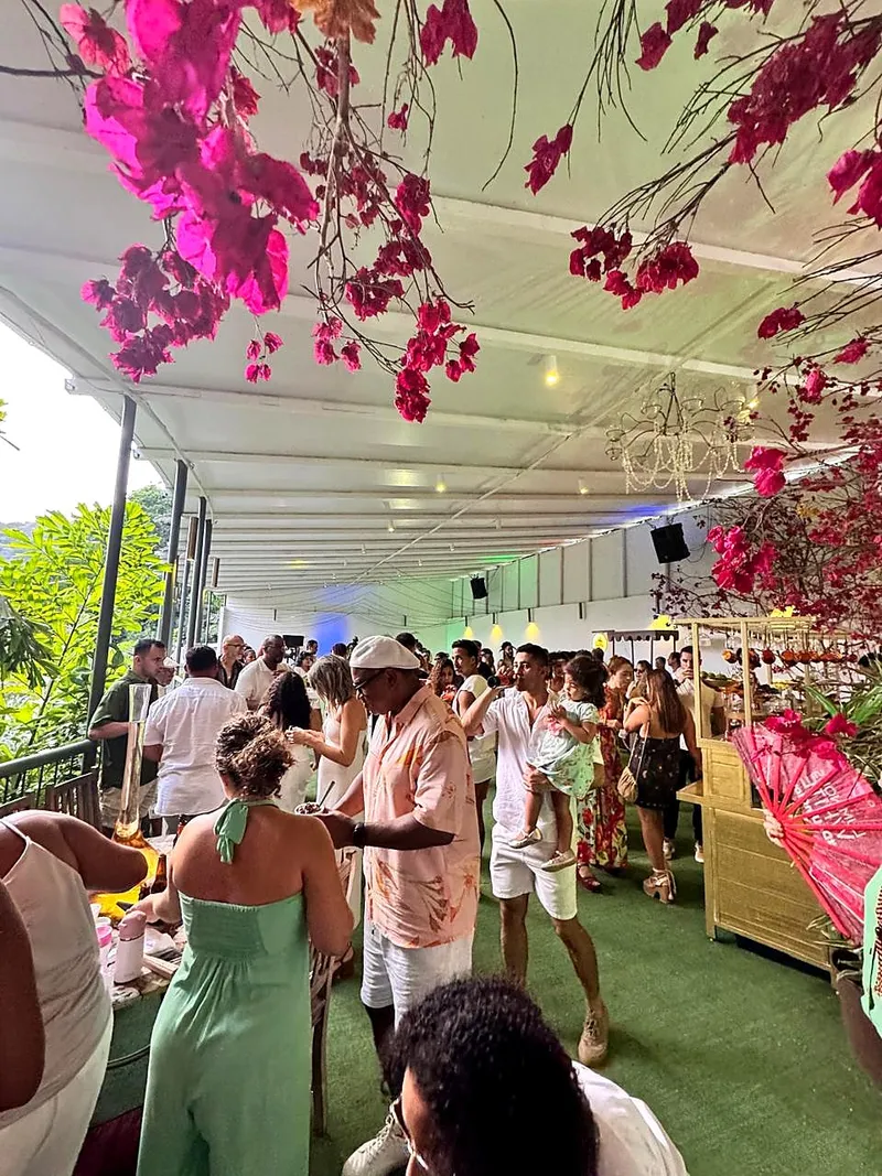 Convidados na varanda decorada com flores rosas suspensas