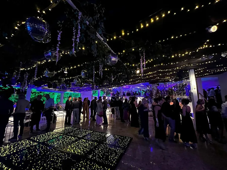 Evento noturno com teto de luzes, globos espelhados e pista de LED na Maison Joá