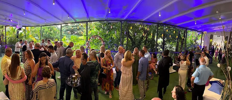 Vista panorâmica de convidados na varanda iluminada em azul