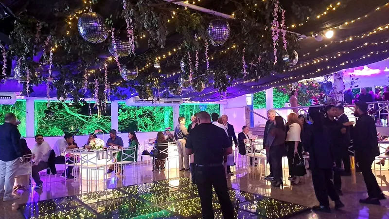 Pista de LED com convidados sob luzes e flores suspensas